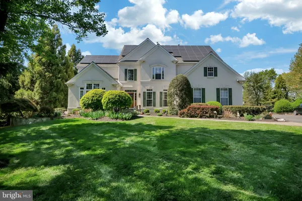 a view of a big house with a big yard and large trees