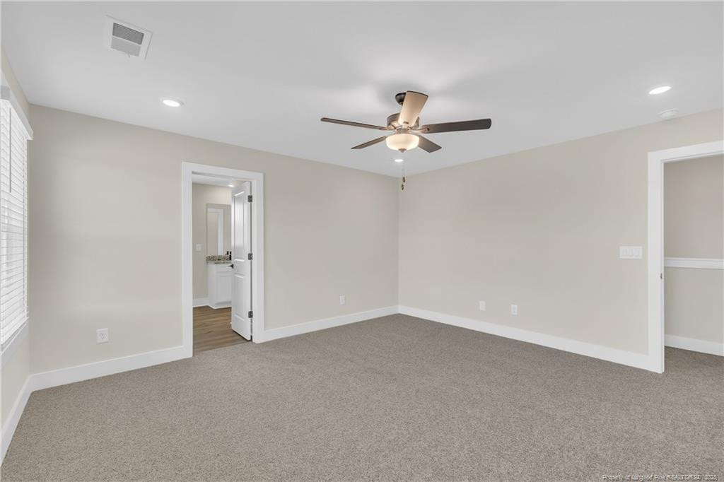 136 Camp Rock Road Lillington, NC 27546 - Photo 23 of 43 an empty room with a ceiling fan and a window