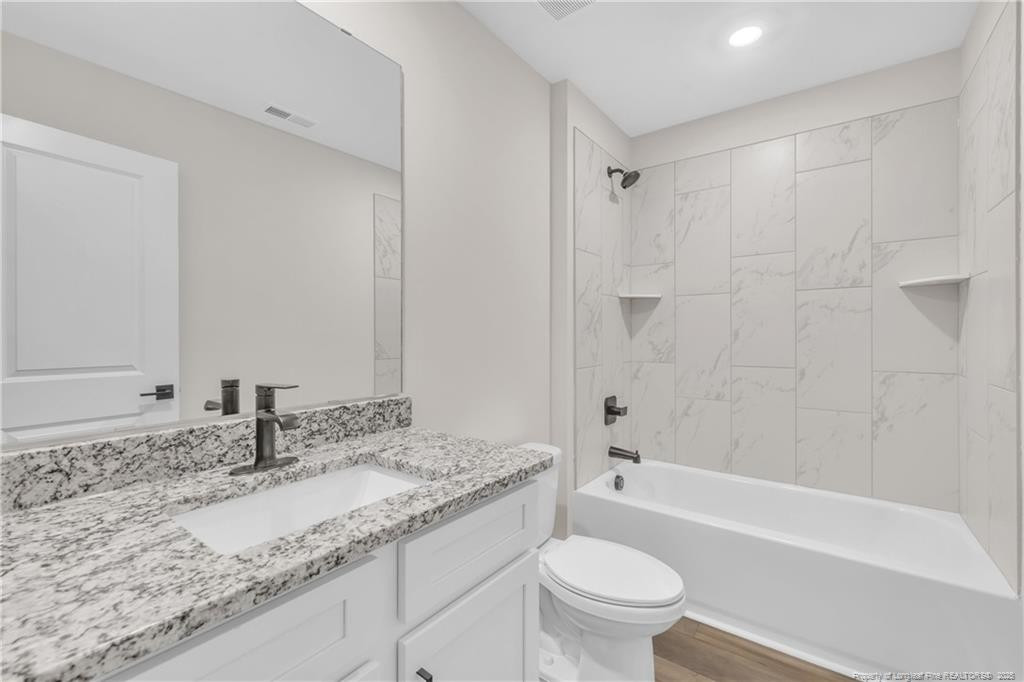 136 Camp Rock Road Lillington, NC 27546 - Photo 35 of 43 a bathroom with a granite countertop sink a toilet and bathtub