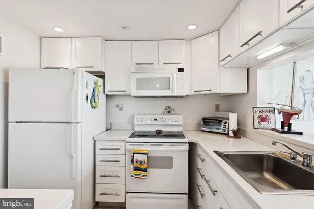 a kitchen with granite countertop a stove a sink and a microwave