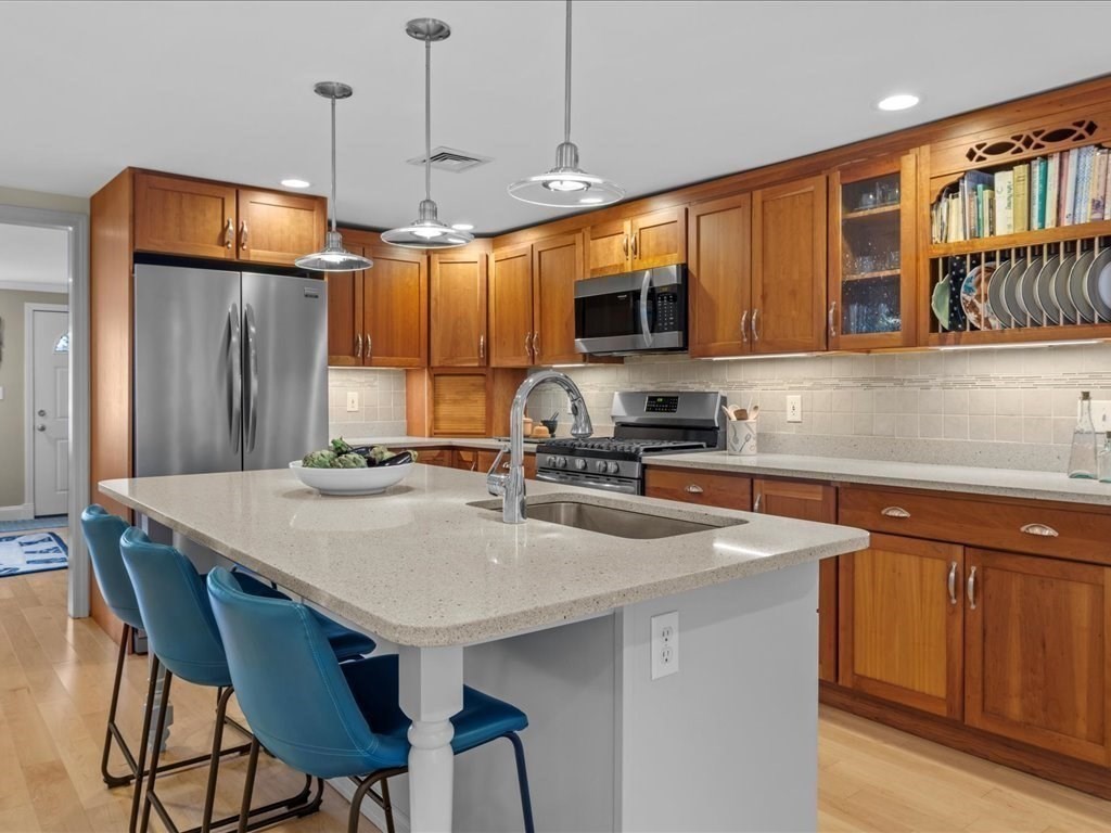 26 Wompatuck Road Hingham, MA 02043 - Photo 4 of 24 a kitchen with stainless steel appliances granite countertop a kitchen island a stove a sink a dining table and chairs
