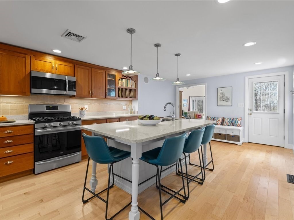 26 Wompatuck Road Hingham, MA 02043 - Photo 5 of 24 a kitchen with stainless steel appliances kitchen island granite countertop a stove a sink and a microwave