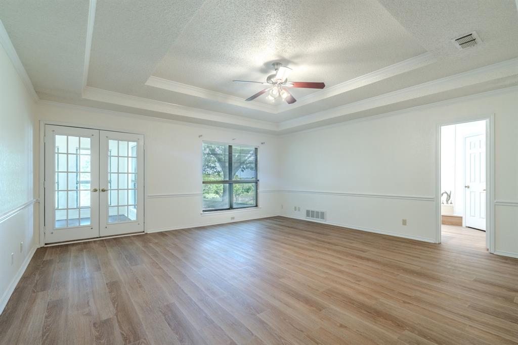 4501 Ridge North Road Fort Worth, TX 76126 - Photo 20 of 39 Primary bedroom with vaulted ceiting, french doors to sunroom and ensuite