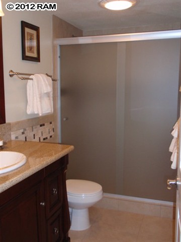 3959 Lower Honoapiilani Road, Unit 305 Lahaina, HI 96761 - Photo 4 of 16 a bathroom with a granite countertop sink toilet and a mirror