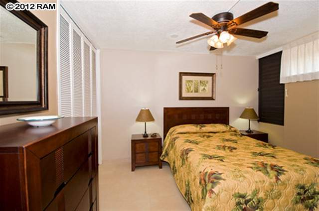 3959 Lower Honoapiilani Road, Unit 305 Lahaina, HI 96761 - Photo 5 of 16 a bedroom with a bed and a chandelier