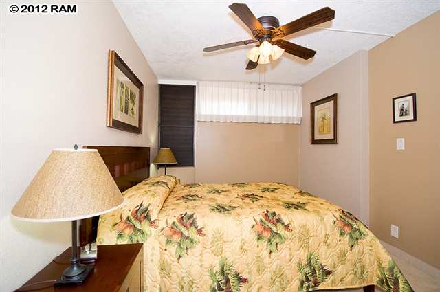 3959 Lower Honoapiilani Road, Unit 305 Lahaina, HI 96761 - Photo 6 of 16 a bedroom with a bed and a lamp