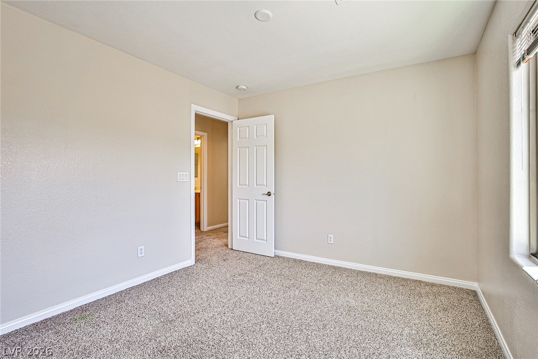8022 Diamond Gorge Road Las Vegas, NV 89178 - Photo 24 of 37 Soft carpeting pairs with neutral walls in this versatile bedroom complete with a classic six-panel door.