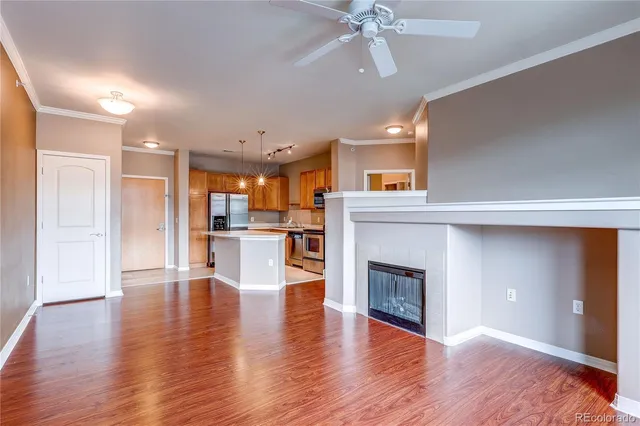 a view of a hallway with wooden floor and a kitchen