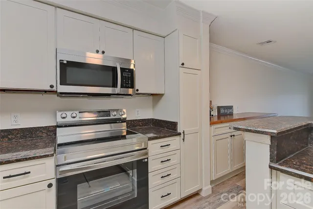 a kitchen with granite countertop cabinets appliances and a counter space