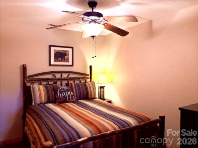 399 Bent Tree Road Maggie Valley, NC 28751 - Photo 34 of 48 a bedroom with a bed and a chandelier