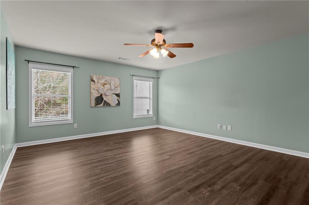 506 Olympic Way Acworth, GA 30102 - Photo 37 of 73 an empty room with wooden floor chandelier fan and windows