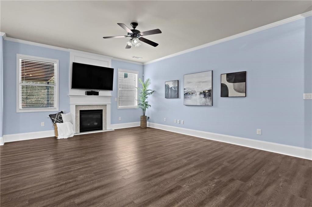 506 Olympic Way Acworth, GA 30102 - Photo 8 of 73 a view of a livingroom with a flat screen tv wooden floor and a ceiling fan