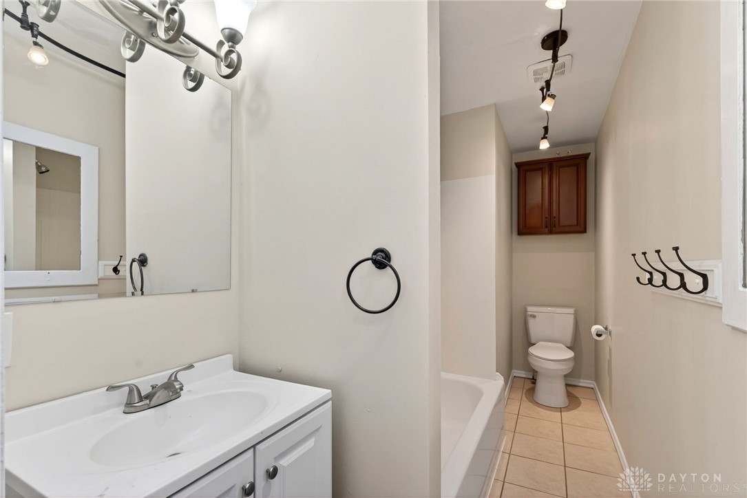 585 North Spring Street Wilmington, OH 45177 - Photo 14 of 21 This clean and functional bathroom features a shower-tub combination, practical tile flooring, and a vanity.