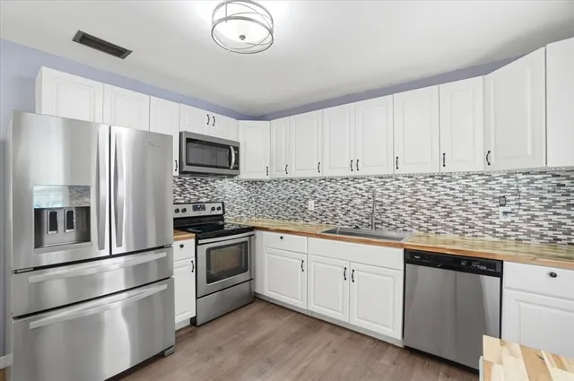 a kitchen with granite countertop a stove and a microwave