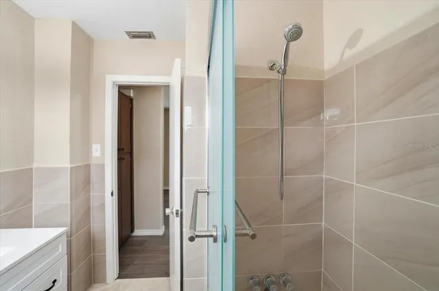 a spacious bathroom with a double vanity sink toilet mirror and shower