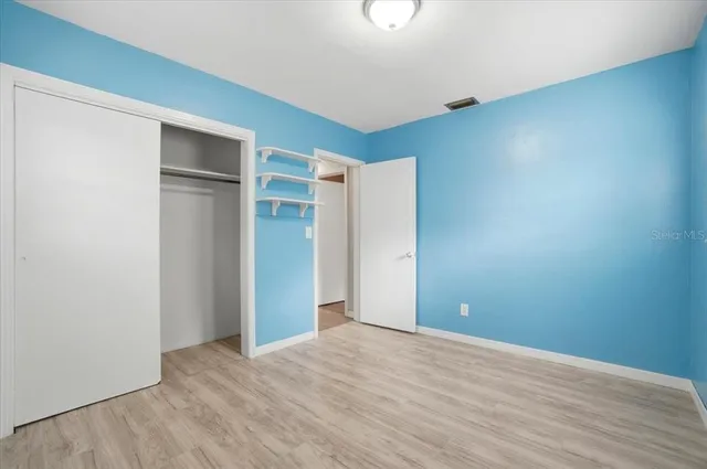 a view of an empty room with wooden floor