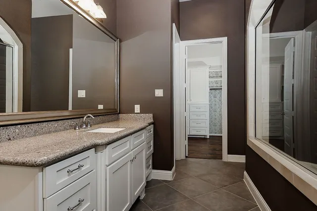 a bathroom with a granite countertop sink and a mirror