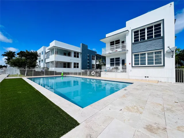 a view of a house with a swimming pool and sitting area
