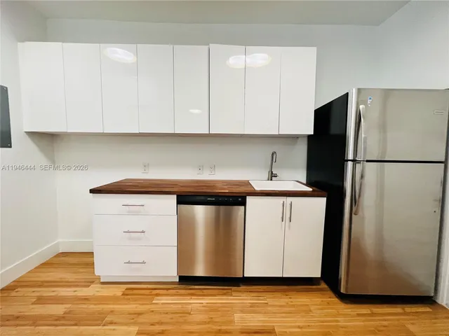 a kitchen with stainless steel appliances white cabinets and a refrigerator
