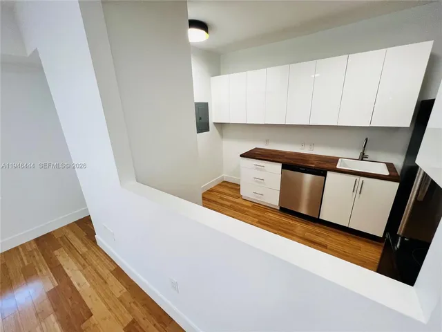 a view of a hallway with wooden floor and staircase