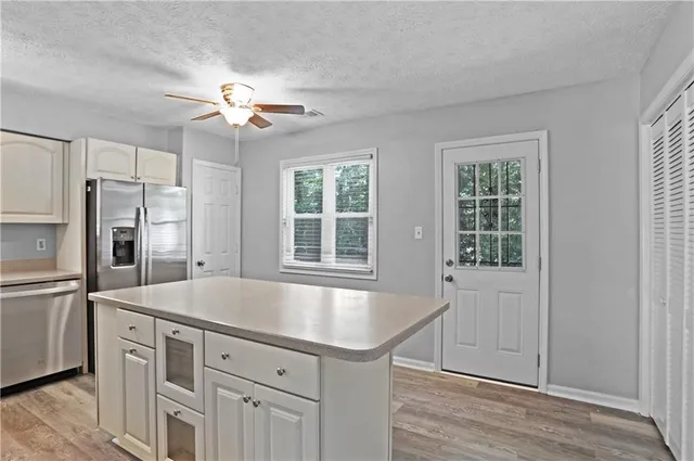 a kitchen with a refrigerator a sink and dishwasher with wooden floor