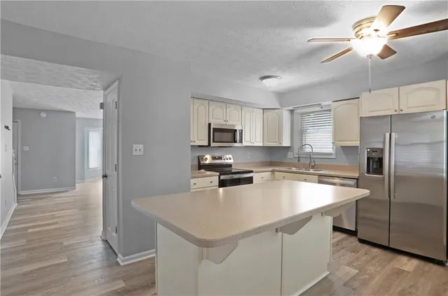 a kitchen with a sink a counter top space cabinets and stainless steel appliances