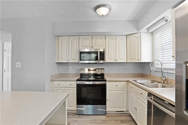 a kitchen with white cabinets and appliances