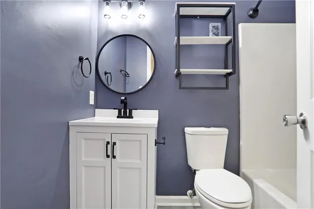a bathroom with a toilet sink and mirror