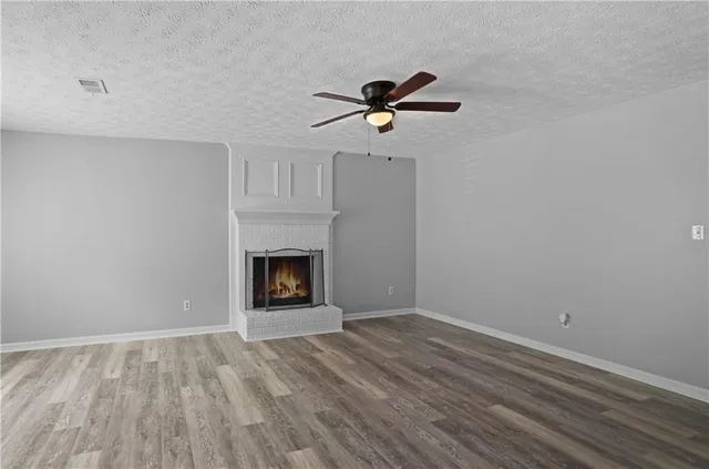 a view of empty room with wooden floor and fireplace