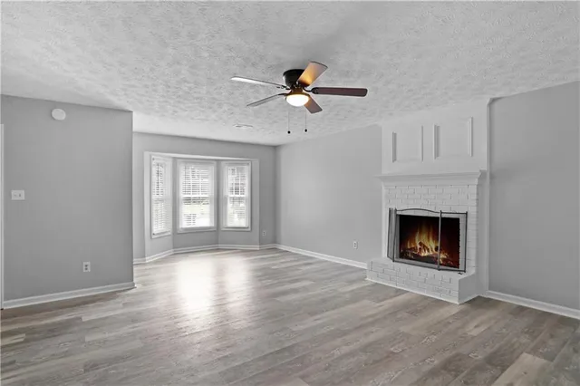 a view of an empty room with a fireplace and a window