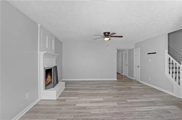 a view of an empty room with a fireplace and a window