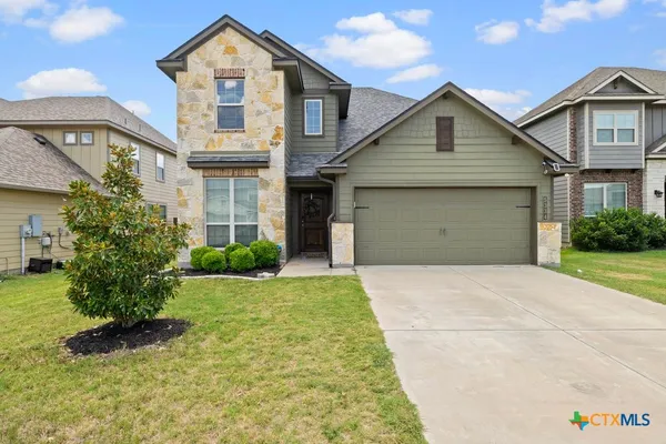 a front view of a house with a yard and garage