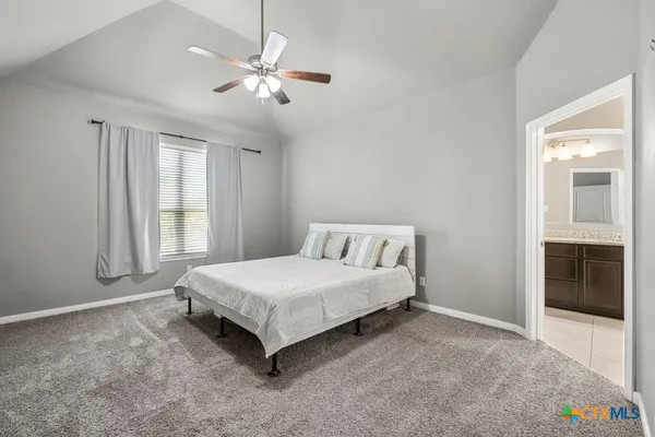 a spacious bedroom with a bed and window