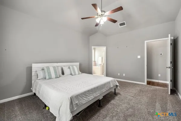 a bedroom with a large bed and a chandelier