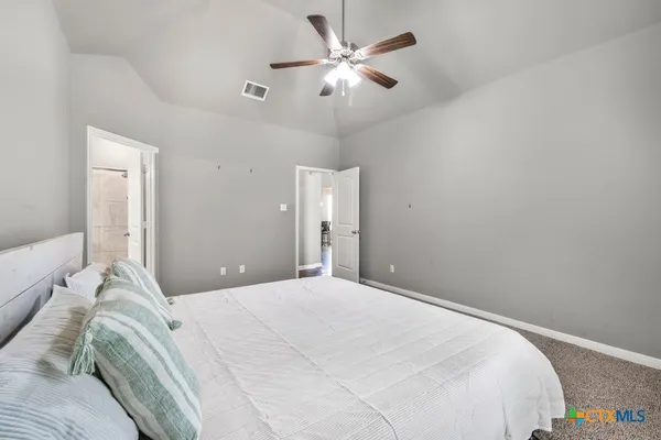 a bedroom with a bed and a ceiling fan