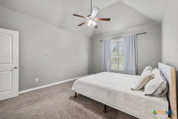 a bedroom with a bed and a ceiling fan