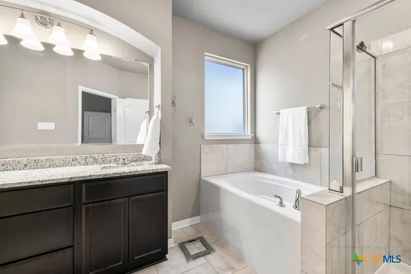 a bathroom with a tub sink and mirror