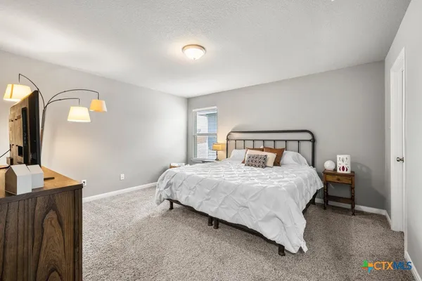a bed sitting in a bedroom next to a window