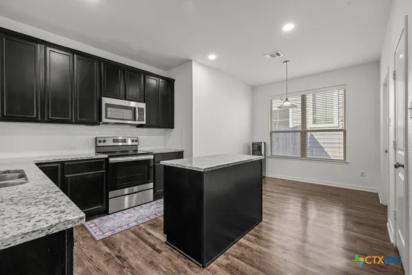 a kitchen with stainless steel appliances granite countertop a stove and a sink