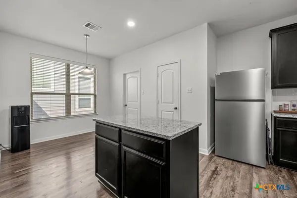 a kitchen with kitchen island a counter top space wooden floor and stainless steel appliances