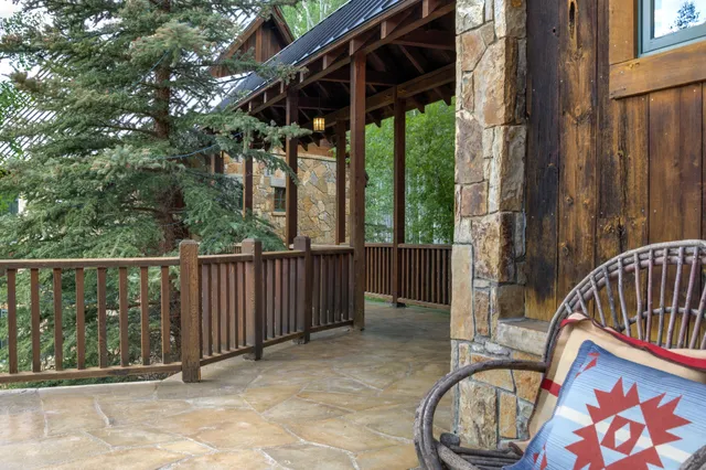 a view of a patio with table and chairs potted plants and large tree