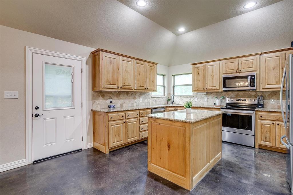 505 N Avenue East Springtown, TX 76082 - Photo 13 of 27 a kitchen with stainless steel appliances granite countertop a stove top oven a sink dishwasher and a refrigerator with wooden floor