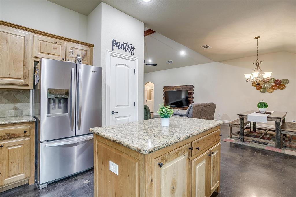 505 N Avenue East Springtown, TX 76082 - Photo 14 of 27 a kitchen with stainless steel appliances granite countertop a refrigerator a stove and a sink with wooden floor