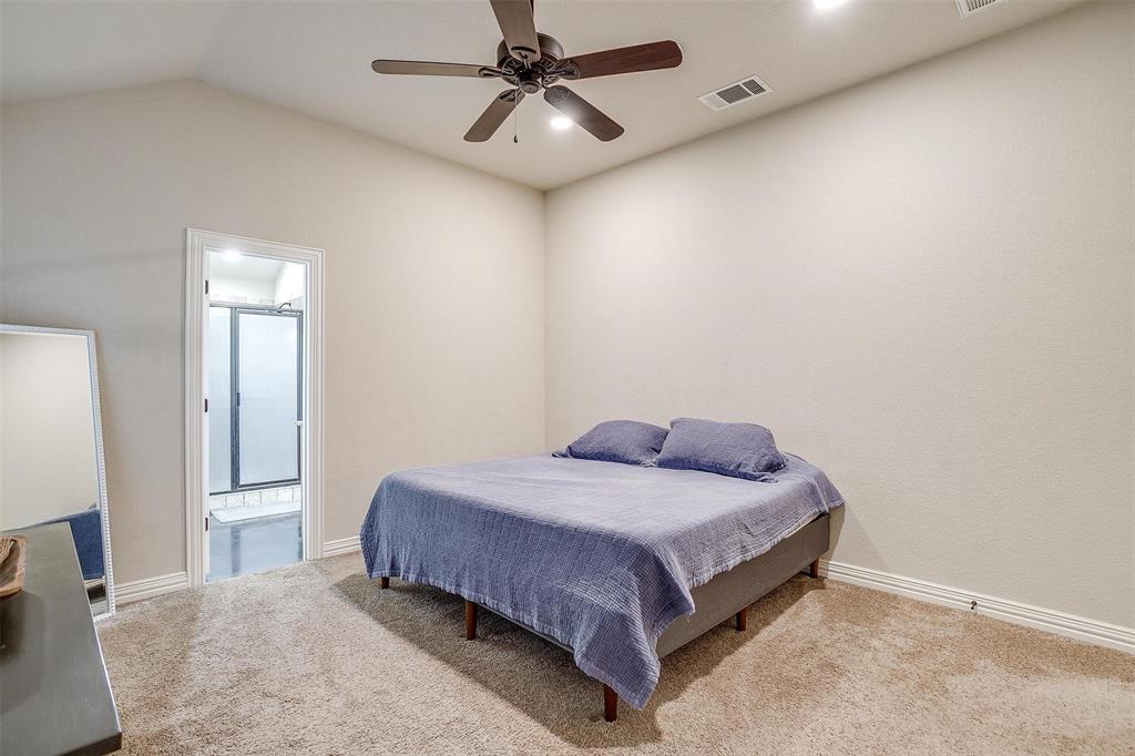 505 N Avenue East Springtown, TX 76082 - Photo 15 of 27 a bedroom with a bed and a chandelier
