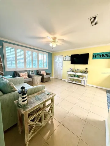 a living room with furniture a flat screen tv and a window
