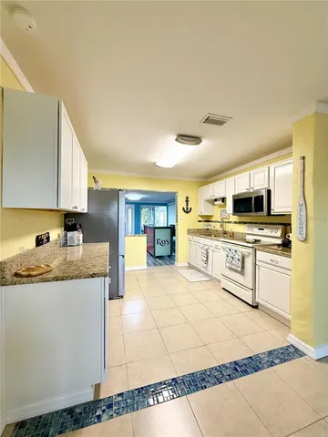 a large kitchen with stainless steel appliances kitchen island granite countertop a sink and cabinets