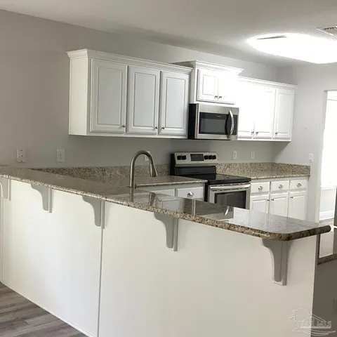a kitchen with stainless steel appliances granite countertop a sink stove and microwave