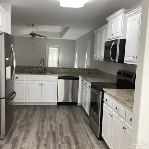 a kitchen with stainless steel appliances granite countertop a stove a sink and a microwave