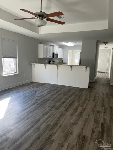 a view of a kitchen with wooden floor and a ceiling fan