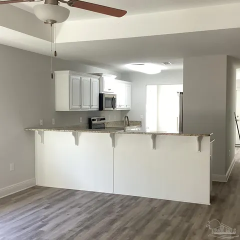 a large kitchen with cabinets stainless steel appliances a sink and a counter space